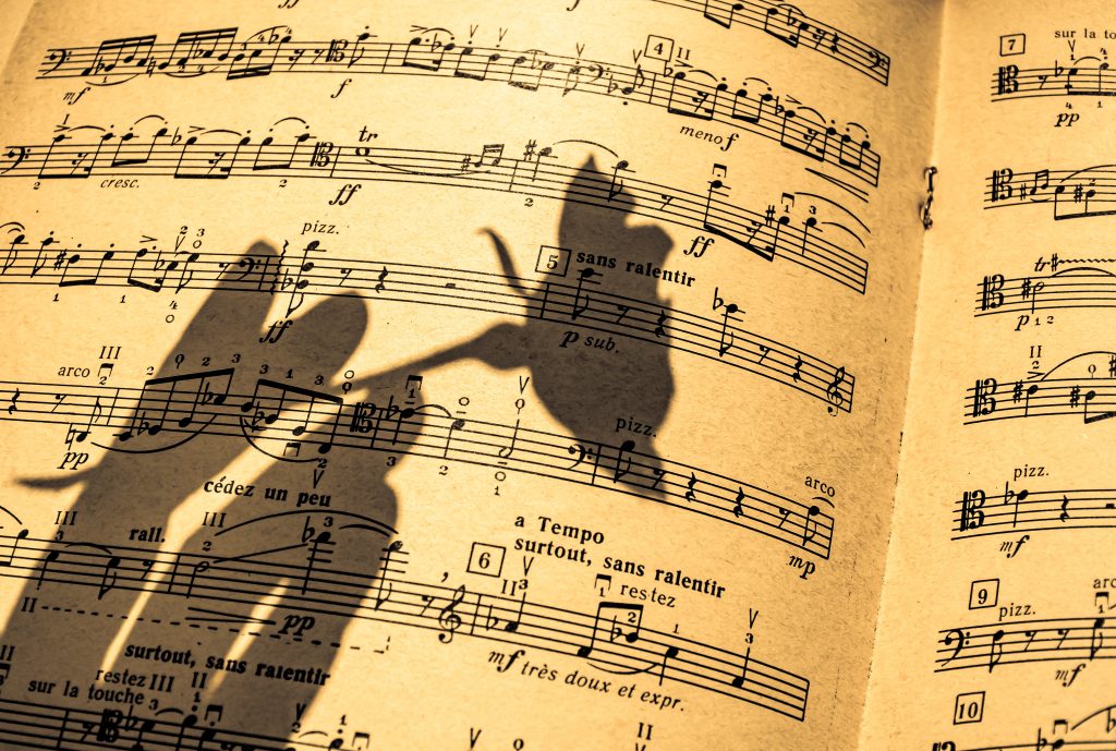 music sheet with shadow of a hand holding a flower